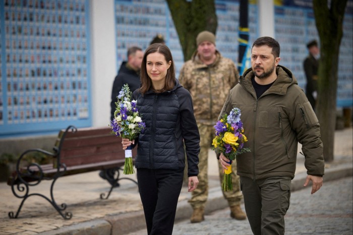 Volodymyr Zelenskyy and Sanna Marin hold flowers in Kyiv