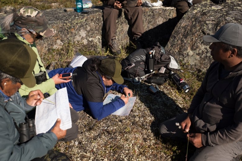 Researchers go over maps.