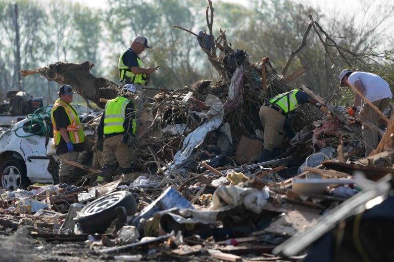 Rescuers search through tornado-strewn debris in Mississippi.