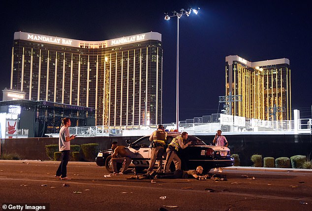 Police hunker down by a squad car outside of the resort in 2017