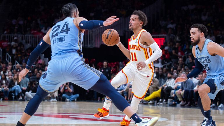 Atlanta Hawks guard Trae Young looks to pass between Memphis Grizzlies forward Dillon Brooks and guard Tyus Jones.