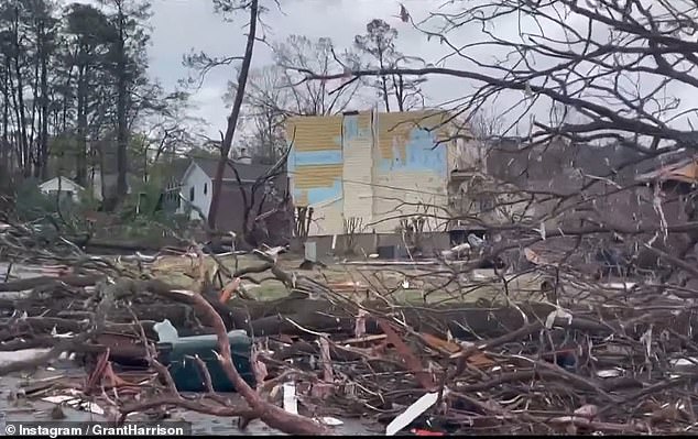 Branches are seen strewn all over the place, while part of the wall from a home came away