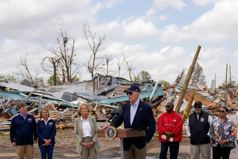 People tour a tornado-hit neighbourhood.