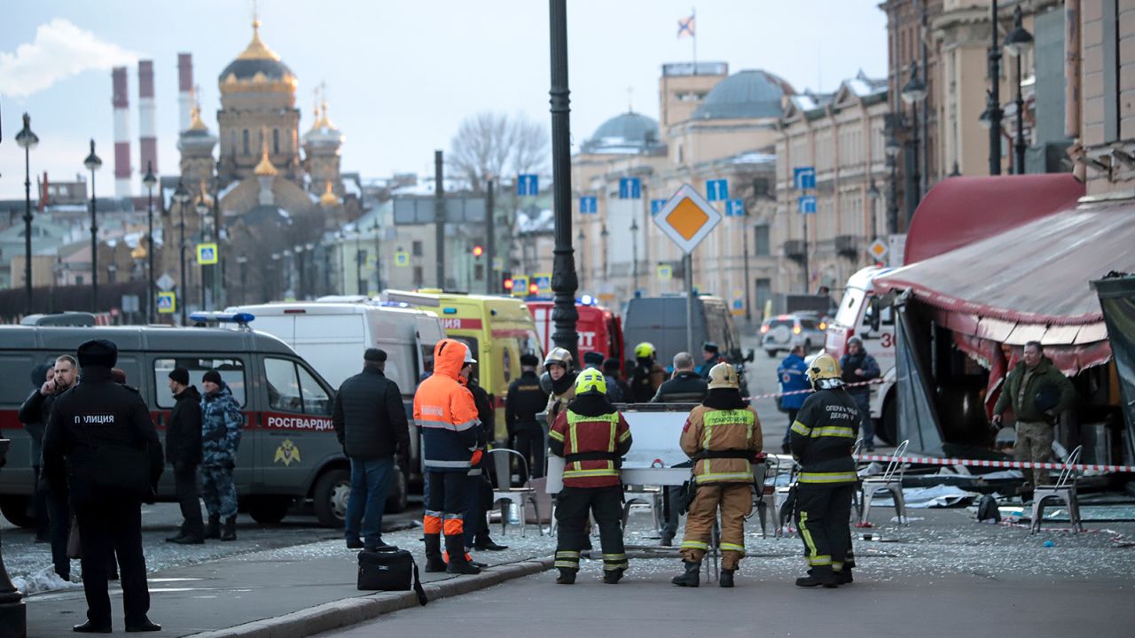 Emergency service workers stand at the site of the blast at the St. Petersburg cafe on Sunday. 