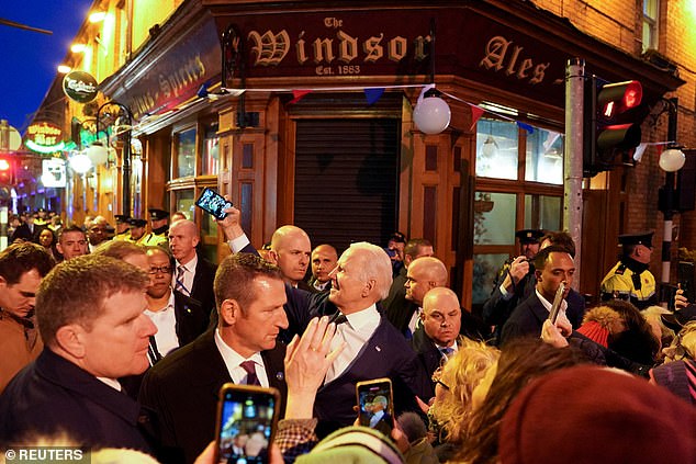 Biden takes a selfie outside the Windsor Bar in Dundalk as crowds line the streets for his visit. The trip featured visits to County Mayo as well as County Lough, where Biden traces family roots