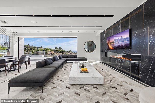 On the other side of the living room, a linear fireplace is ensconced in Italian black marble