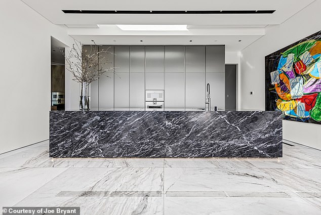 Clean lines dominate the property with black and white marble finished throughout the kitchen space