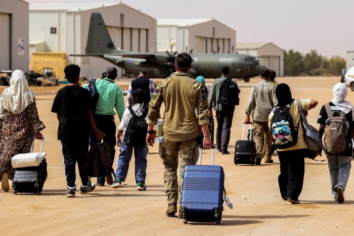 People walking at a tarmac with their luggage