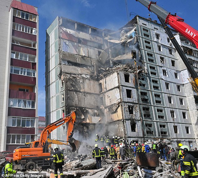 Rescuers search for survivors in the rubble next to damaged residential buildings in Uman, south of Kyiv on Friday after Russia launched missile strikes on Ukraine