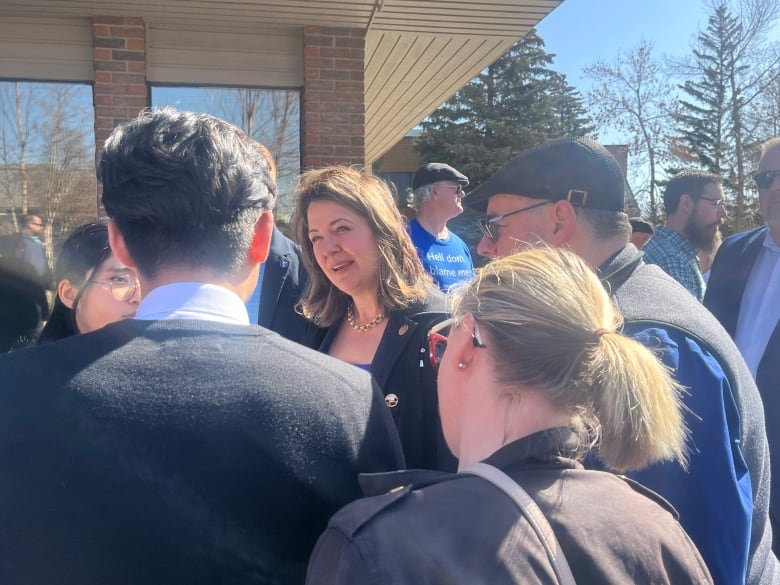 A woman talks to a crowd.