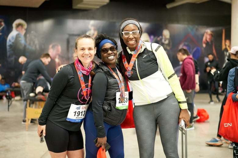 Three people with medals on smile, standing together.