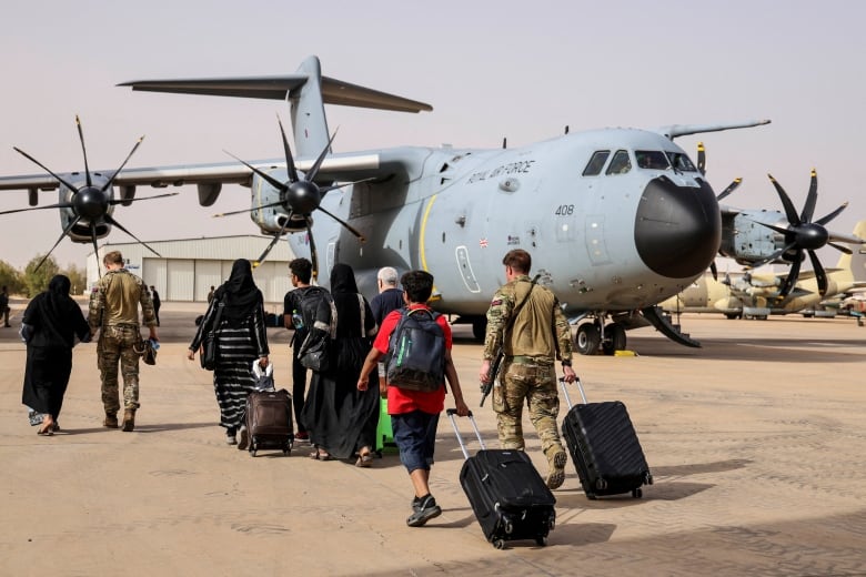 People walk toward a plane.