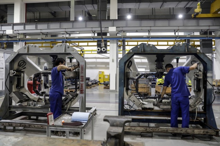 Employees work on the production floor at the Voith Turbo Power Transmission Co. auto parts factory in Shanghai