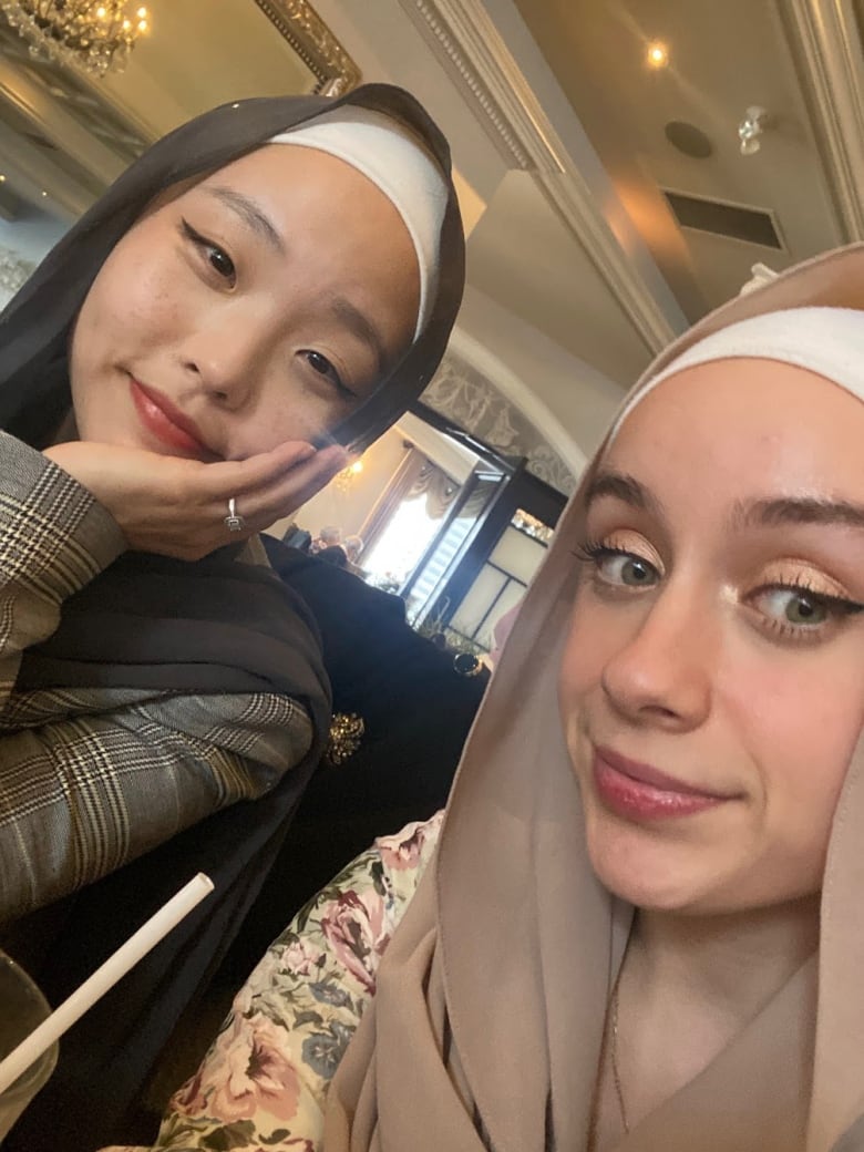 Two women in headscarves smile. 