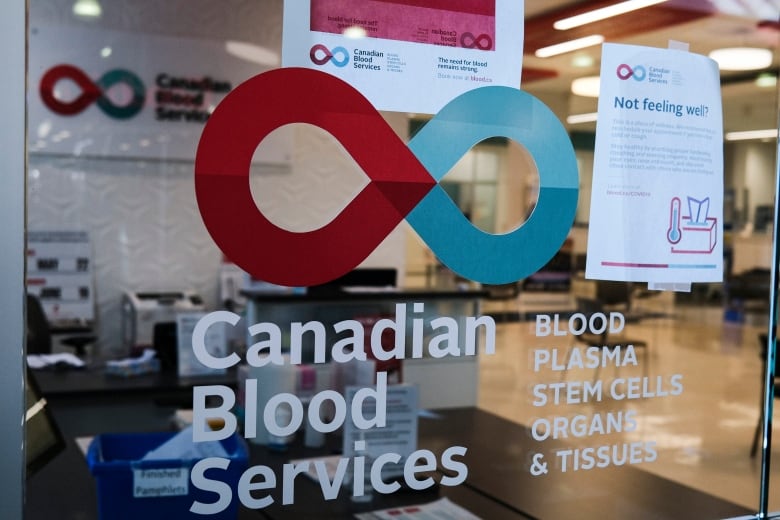 A blood donor clinic pictured at a shopping mall in Calgary. The window is printed with  'Canadian Blood Services' and a red and blue logo.