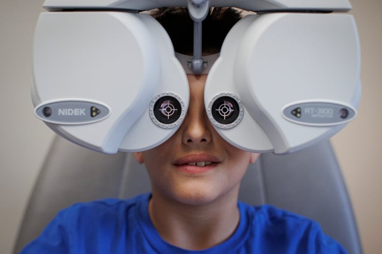 A young boy's eye's are examined in an eye doctor's clinic.