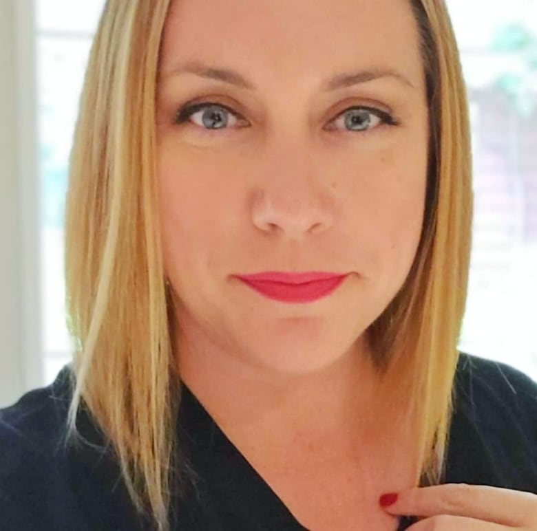 A woman with blonde bobbed hair poses for a selfie.