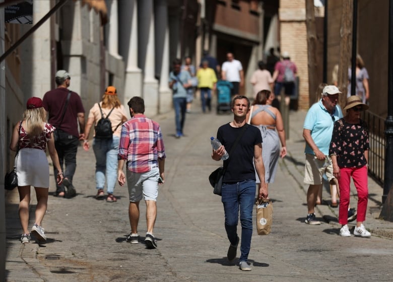 A man carries a bottle of water.