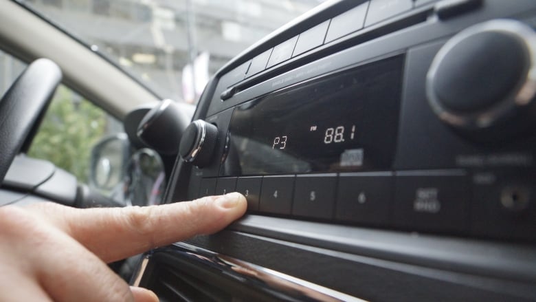 A hand touches a car dashboard.