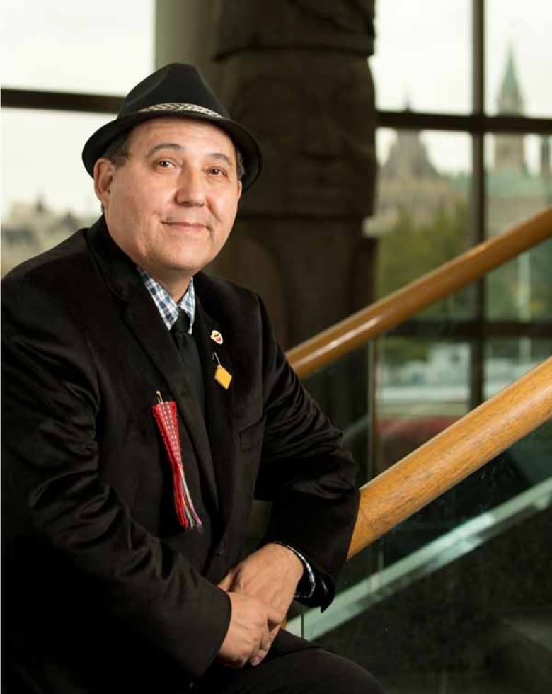 A portrait of a man leaning on a railing.