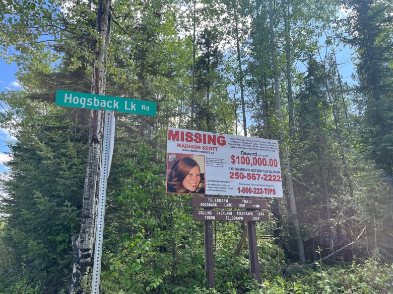 A missing poster of Madison Scott beside a street sign that says Hogsback Lake Rd.