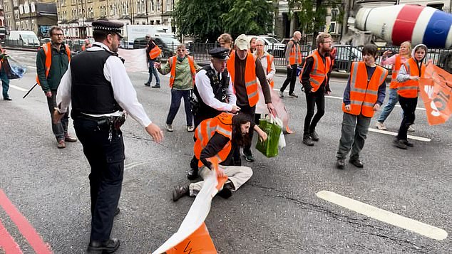 The defiant protesters resist and remain in the middle of the road with their banners