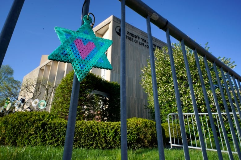 A Star of David hangs on a fence outside a synagogue.