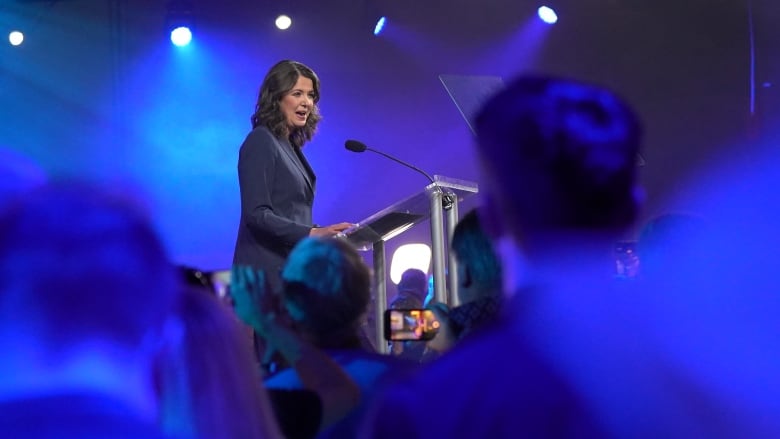 A woman stands at a podium