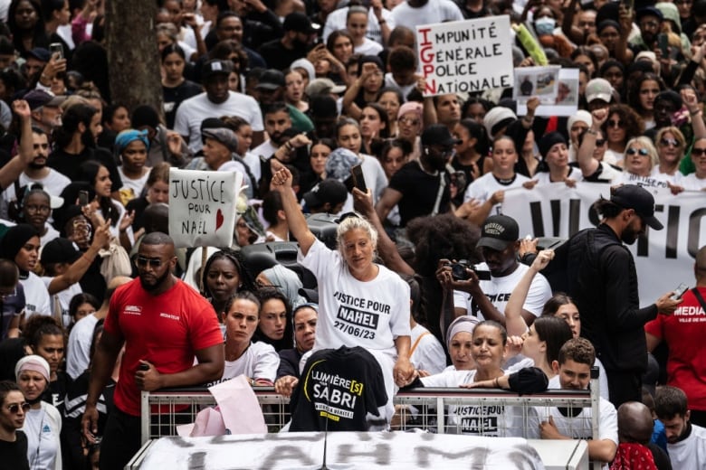 Protesters ride in cars and walk on the street.