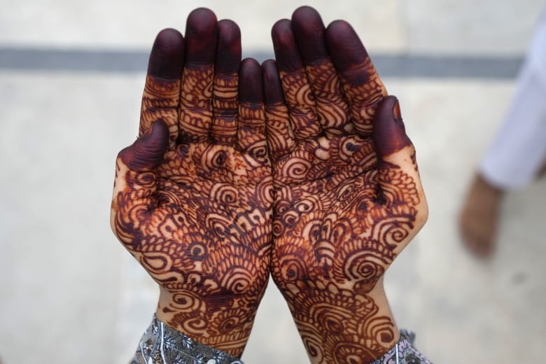 A woman's hand is covered in Henna