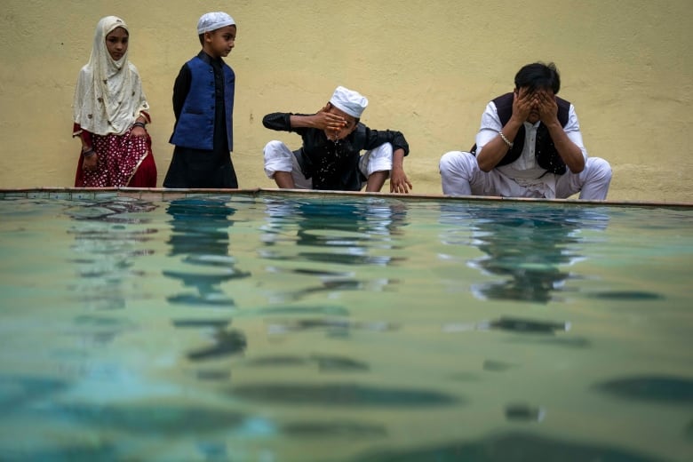 A Muslim family is pictured by a body of water while celebrating Eid al-Adha.