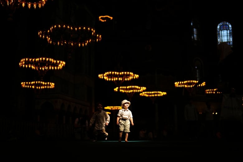 A young boy walks through a glow of lights at the Hagia Sophia mosque in Turkey.