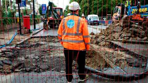 Thames Water employees in high-vis gear work at a burst water pipe in Brixton Hill, London