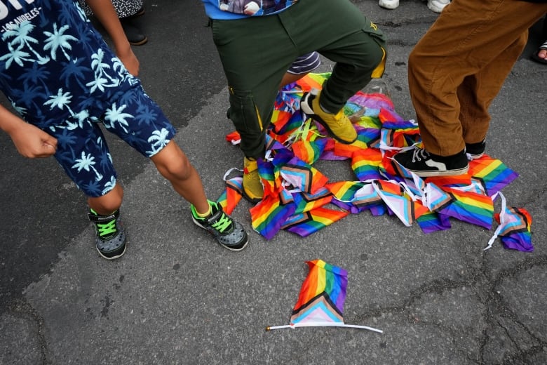 Pride flags lying on the streets and children stomping on them.