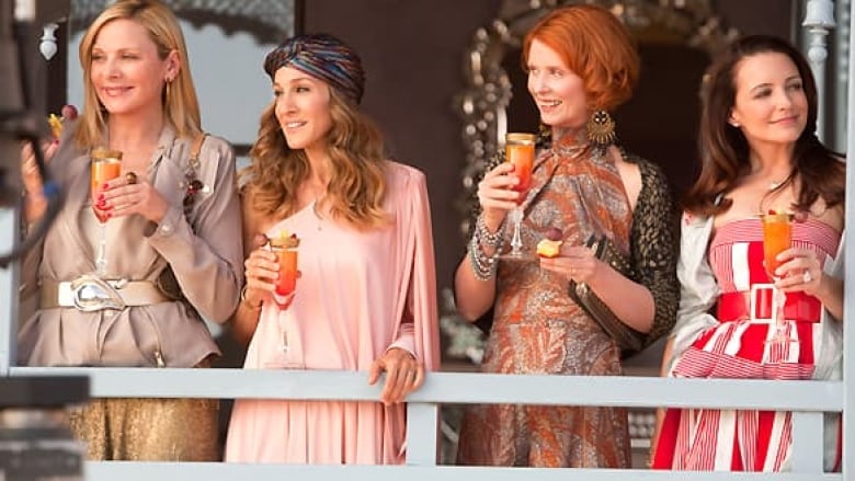 Four fashionable women holding cocktails