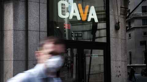 A man wearing a facemask passes the entrance to the restaurant