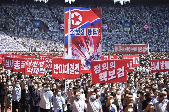 A mass march in Pyongyang, North Korea with participants holding banners