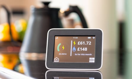 Closeup of the screen of a smart meter display in a kitchen, showing the monthly cost of electricity and gas so far.