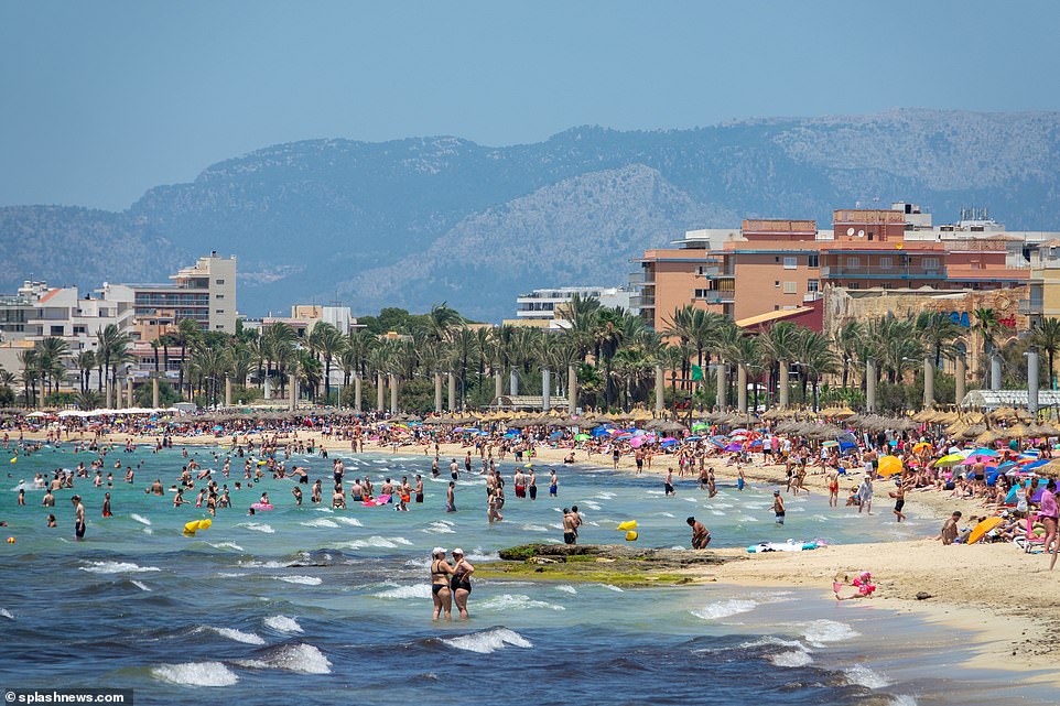 The blue ocean brought tourists playing in the surf - while every inch of the sand appears plastered in towels and umbrellas