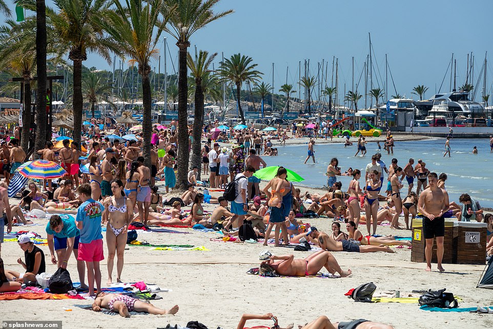 The packed beach and palm fronds of the famous resort bring tourists flocking to the sunny holiday spot