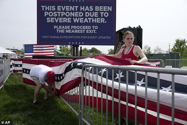 Trump was forced to cancel a rally in Iowa last month as a storm closed in. Workers are pictured dismantling structures at the site after it was postponed