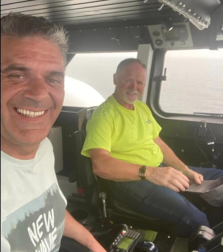 Gino LeBlanc and Paul Tobin smile for a photo inside the hovercraft as it rains outside