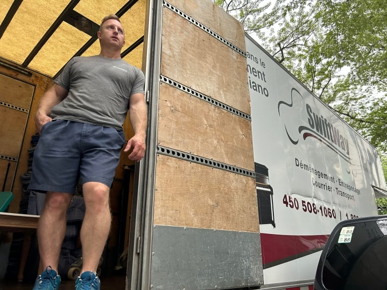 A man stands in a moving truck.