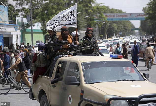 Taliban fighters flying their flag drive through the centre of Kabul in 2021 as they try to maintain security in the capital