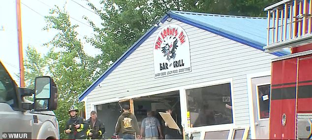 Fire officials are seen removing the mess of debris from the store on Sunday afternoon, after removing the Acura