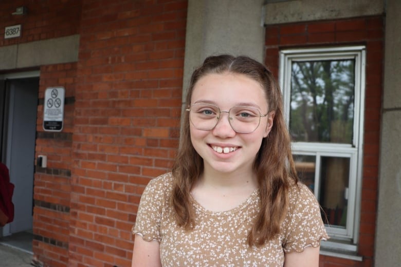 A student wearing smiles at the camera.