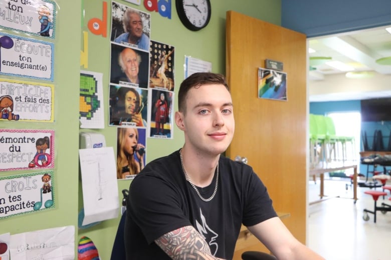 A man sits at a desk in an elementary school 