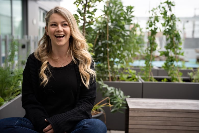 A peer support worker sits in a rooftop garden and laughs at the Union Gospel Mission's support centre for women in Vancouver.