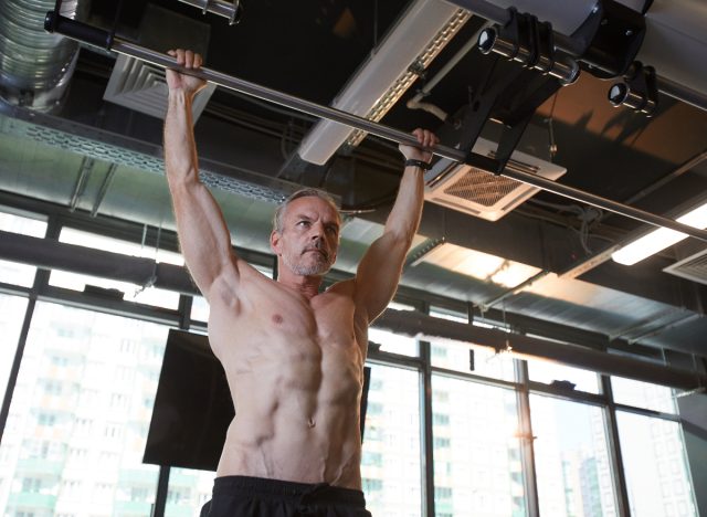 muscular man doing pull-ups exercise