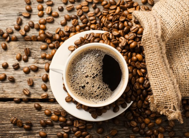 coffee cup surrounded by coffee beans